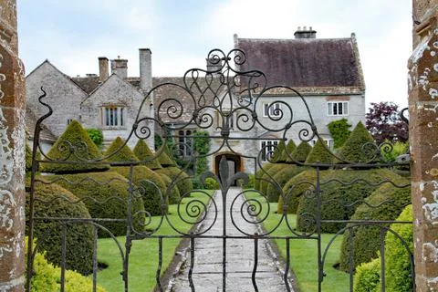 An old flag stone path leads up to an English country house viewed through a  스톡 사진