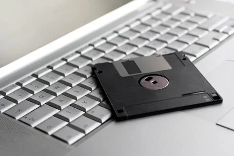Old floppy disk on a silver keyboard Stock Photos