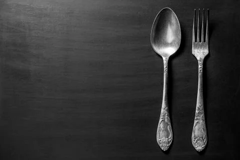 Old fork and spoon over black background Stock Photos