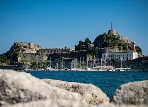 Old Fortress in Corfu town with boats in harbour below Stock Photos