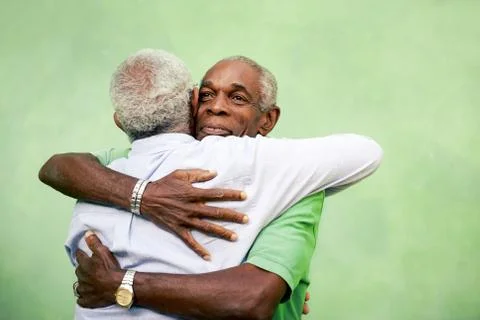 Old friends, two senior african american men meeting and hugging Stock Photos