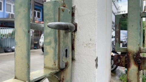 Old front metal rusty door fence at home daytime with blurred car passing by Stock Footage 247133566