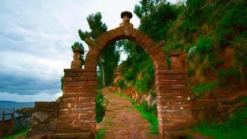 Old gate in the form of an arch of bricks, standing in a picturesque place Stock Photos