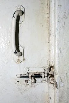 An old gate valve from the Soviet Union.An old Russian latch for the door. Stock Photos