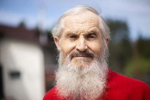 Old generation. Portrait of positive senior bearded man standing outdoors and Stock Photos