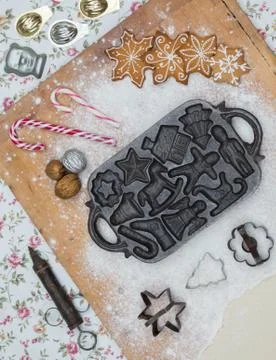 Old gingerbread maker baking sheet on wooden table with antiquities Stock Photos