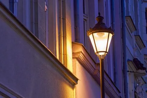 An old glowing lantern on a purple wall background during the night Stock Photos