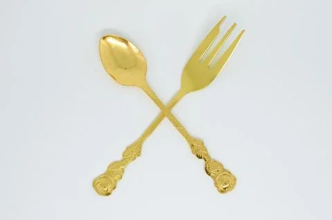 Old gold-plated spoon fork crossed with each other Stock Photos