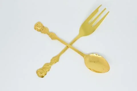 Old gold-plated spoon fork crossed with each other Stock Photos