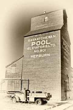 An old grain elevator with a truck in front of it Stock Photos