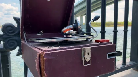 Old gramophone in leather case put by bridge plays melody Stock Footage 204825310