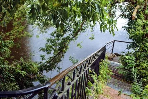 Old granite staircase going down to the water on background of the river. Stock Photos