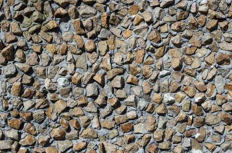Old granite wall of small stone fragments Stock Photos
