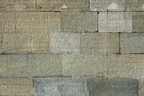 Old gray brick wall of large beige blocks. rough surface texture Foto stock