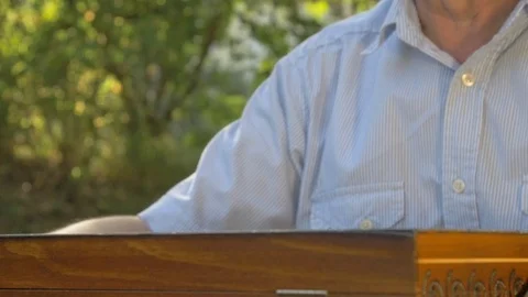 Old gray-haired man opens the chess game outside in the garden at the table and Stock Footage 118693771