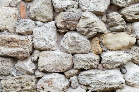Old gray rough stone wall. Close-up Stock Photos