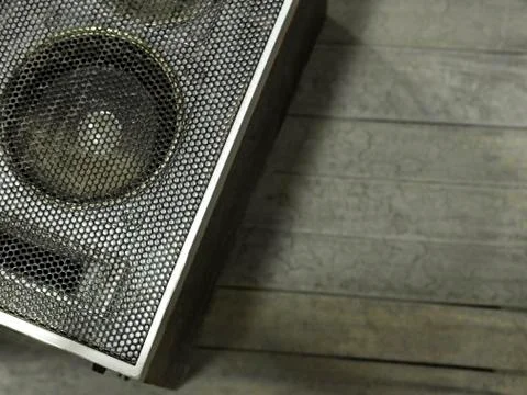 Old gray speaker on a gray background. Stock Photos