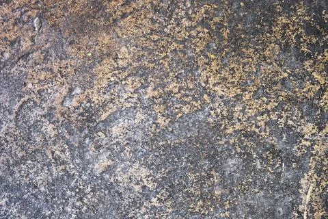 Old gray stone wall with orange paint stains and deep relief. rough surface t Stock Photos