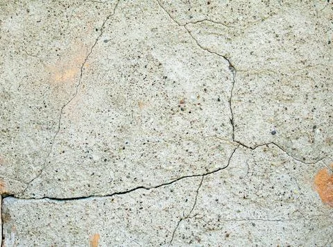 Old gray wall covered with cement plaster with deep cracks Stock Photos