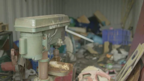 Old green drill press in cluttered workshop Video stock 347035615