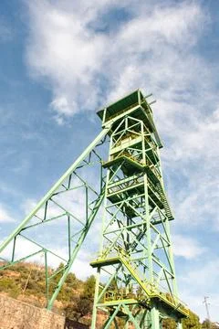 Old green mining tower with the sky in the background. Stock Photos