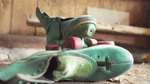 Old green roller skates with red wheels in shed / Focus on top skate Stock Footage 130885937