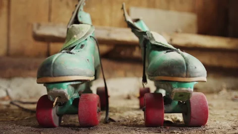 Old green roller skates with red wheels in shed / Side by side Stock Footage 130885962