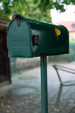 Old green US mail box with rust stains and vintage details on rainy street Stock Photos