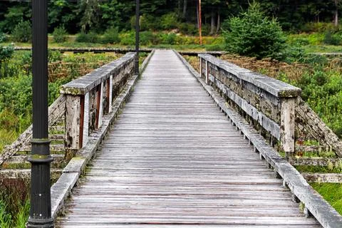 An old grey moss covered boardwalk with rails Stock Photos