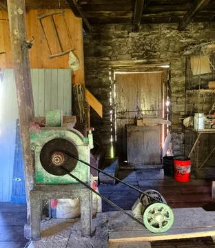 Old grinding machine in rustic cabin Stock Photos