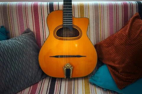 An old Gypsy guitar on the couch Stock Photos