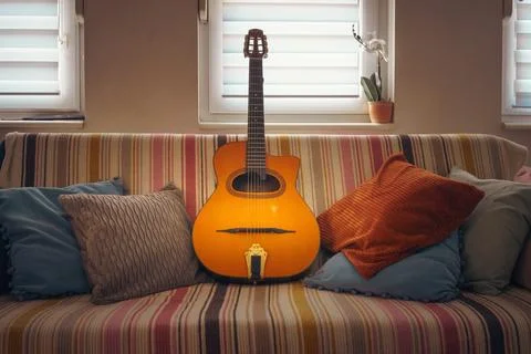 An old Gypsy guitar on the couch Stock Photos