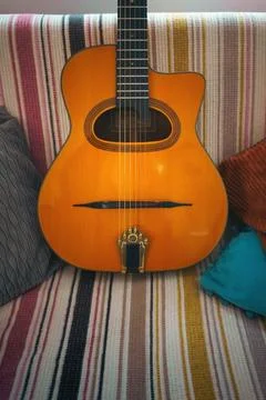An old Gypsy guitar on the couch Stock Photos