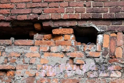 Old half destroyed stone wall of red bricks Stock Photos