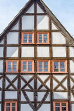 Old half-timbered house with rustic wooden windows Stock Photos