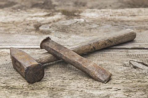 Old hammer and rusty chisel on a wooden unpainted workbench Stock Photos