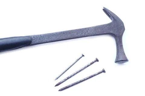 Old hammer and three rusty iron spike nails Stock Photos