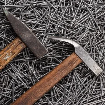 Old hammers and nails on table Foto stock