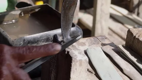 Old hand rubber worker sharpening tapping knife blade whetstone outdoors, m.. Stock Footage 328657197