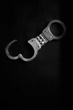 Old handcuff on table in white tone, criminal justice concept Stock Photos