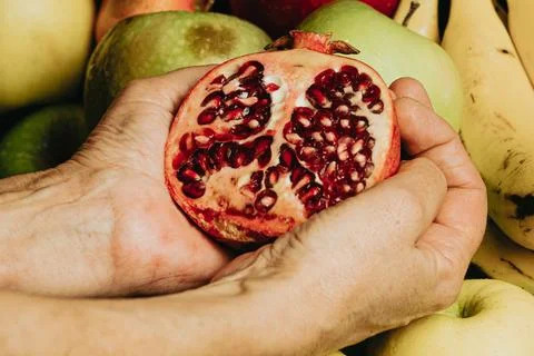 Old hands grabbing a passion fruit over a full of fruits background with wa.. Stock Photos