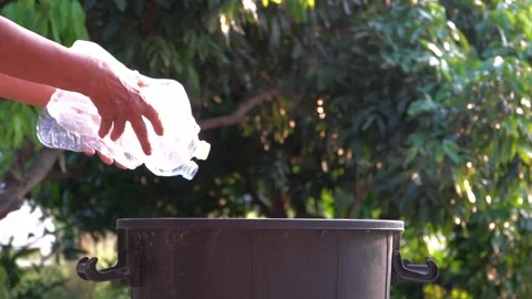 Old hands holding garbage in to a bin , protect environment from a pollution Video stock 158532543