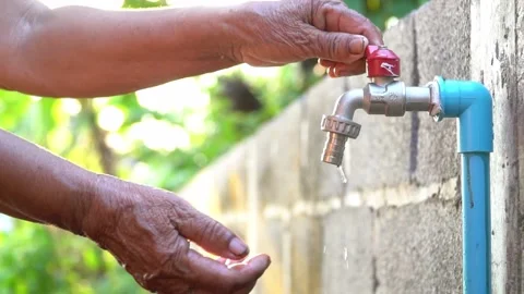 Old hands open the faucet. Video stock 158532719