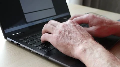 Old hands typing on laptop keyboard. Senior man using technology close up Stock Footage 239408605