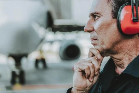 Old handsome worker looking thoughtfully in the direction Stock Photos