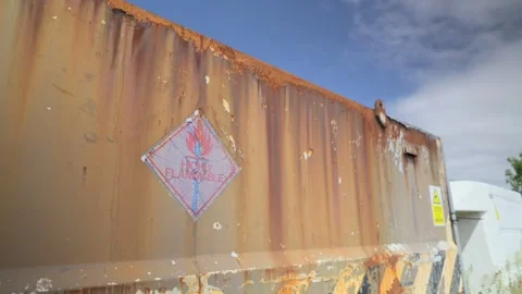 Old highly flammable warning sign on rusted derelict container, slow Stock Footage 244825802