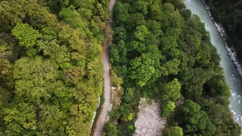 An old highway in the mountains and a mountain river. The view from the drone. Stock Footage 220573150