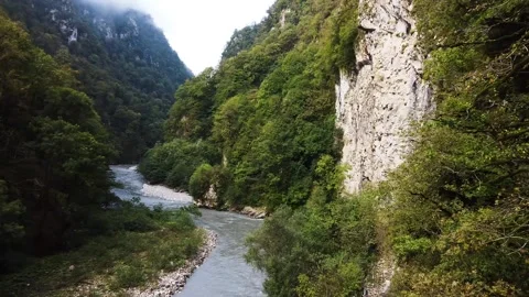 An old highway in the mountains and a mountain river. The view from the drone. Stock Footage 220573746