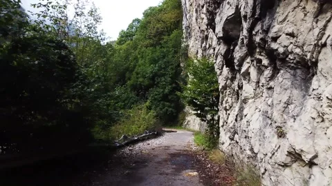 An old highway in the mountains and a mountain river. The view from the drone. Stock Footage 220574173