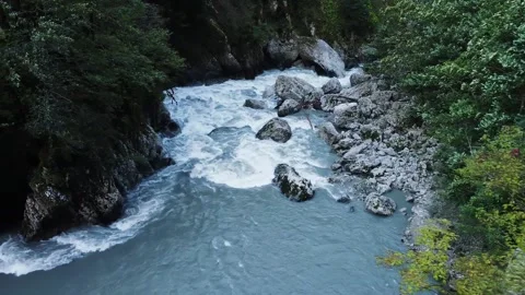 An old highway in the mountains, and mountain river in gorge. Aerial view drone. Stock Footage 220574447